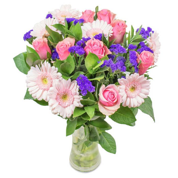 Elegantly arranged in a pristine glass vase and set against a pure white backdrop, this West Heath bouquet exudes artistry and vibrancy. Anchoring the display are approximately 7-9 pink roses, showcasing a range of bloom stages-from tightly furled buds to delicately opening petals, all spiraling in classic formation and evoking the subtle romance of a spring in West Heath. Interspersed are 5-7 pale pink gerbera daisies, each marked by a wide, round head and luminous, soft-white central disc. Clusters of vivid purple statice or limonium are woven among the larger blooms, offering a dynamic textural interplay and a deeper pop of colour. Thick, deep green foliage bases the bouquet, adding volume, freshness, and the faint aroma of local gardens. The glass vase reveals straight stems and sparkling water, reinforcing the bouquet's immediate freshness-a hallmark of a same-day delivery from a trusted West Heath florist. Perfect for birthdays, anniversaries, or marking meaningful occasions, this composition is an emblem of celebration, natural beauty, and West Heath's enduring community warmth.
